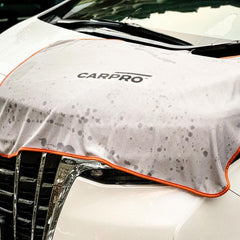 CARPRO DHydrate drying towel on car surface demonstrates water removal with a streak-free finish