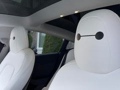Generic Tesla seat eye decals with Baymax eyes for personal touch in cabin.