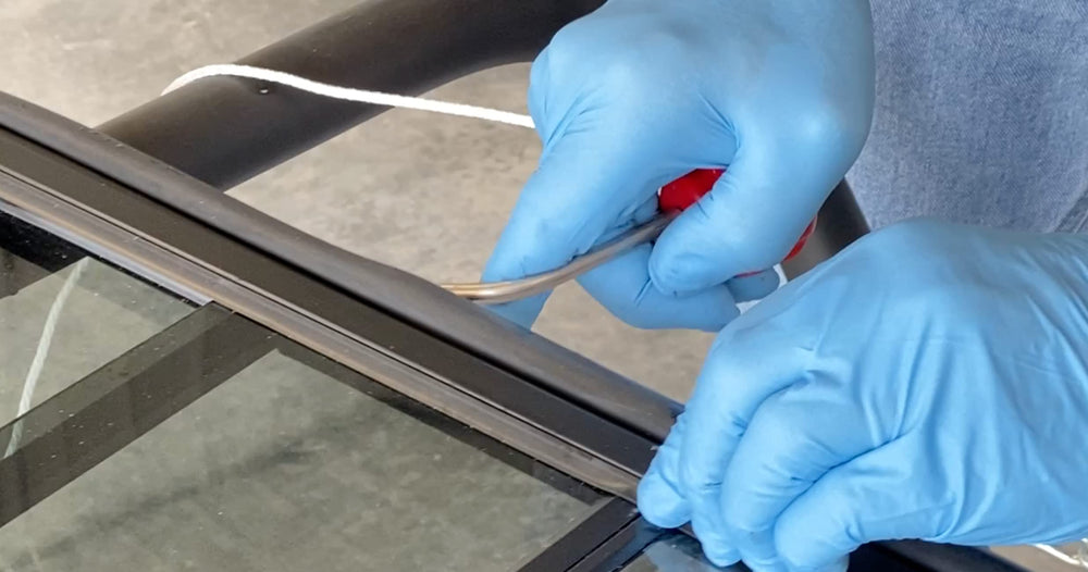 Lisle 83660 gasket rope insert tool red in use demonstrates durable nylon rope around large windshields.