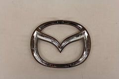 Mazda front logo emblem close-up, durable construction for long-lasting exterior shine.