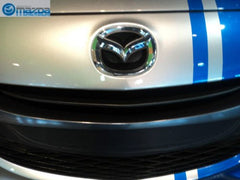 Mazda emblem front view, authentic OEM design for confident replacement.