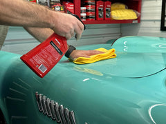 Mothers California Gold Instant Detailer near car panel removes dust for quick between-wash maintenance.