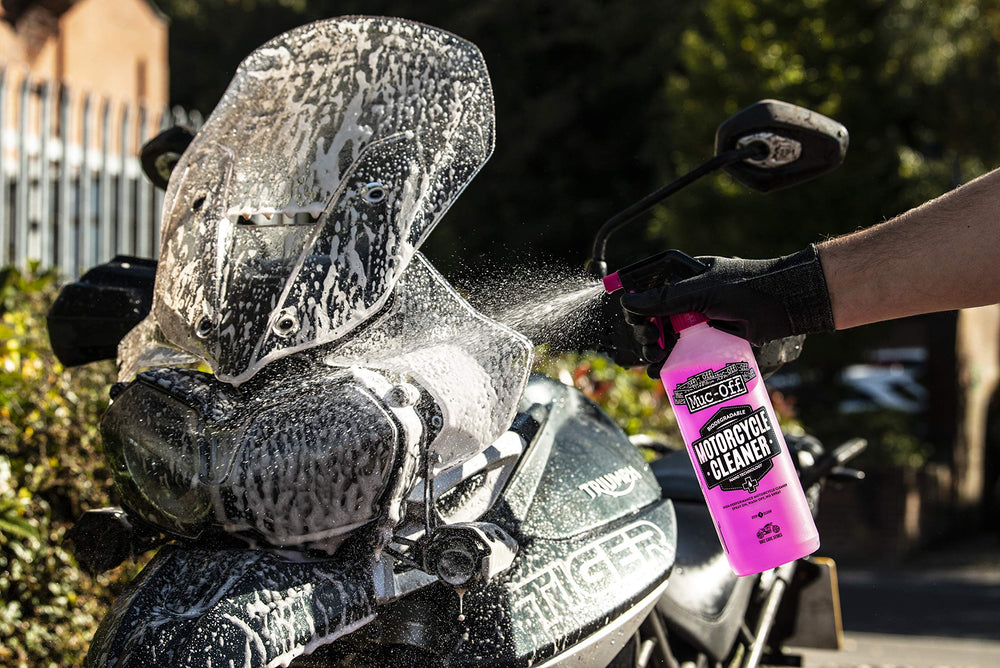 Muc-Off cleaner applied on a bike, lifting grime with a bright pink foam