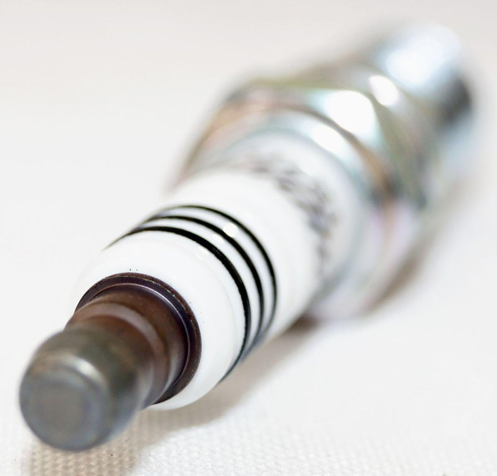 NGK spark plug held in hand for close inspection