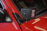 Rough Country lower windshield LED brackets installed on a Jeep Cherokee XJ for improved off-road lighting.