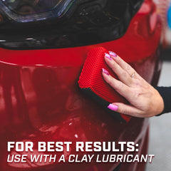 The Rag Company Reset Clay Scrubber 2-pack rests in a wet bucket for reuse.