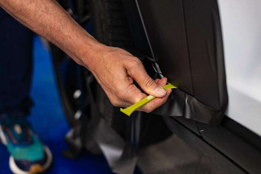 The Wrap Institute tool in use on a vehicle wrap demonstrates precise cutting.