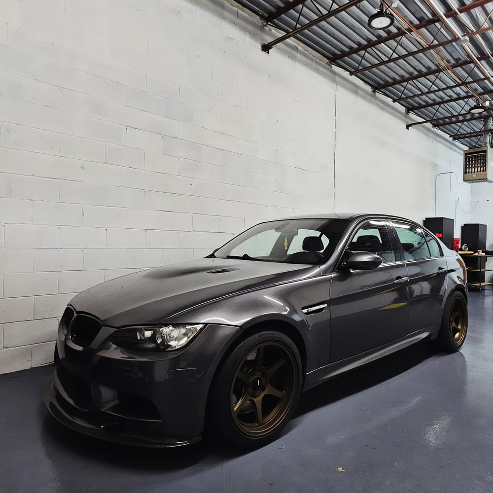 Close-up of high-gloss charcoal grey car surface finished with VViViD wrap.