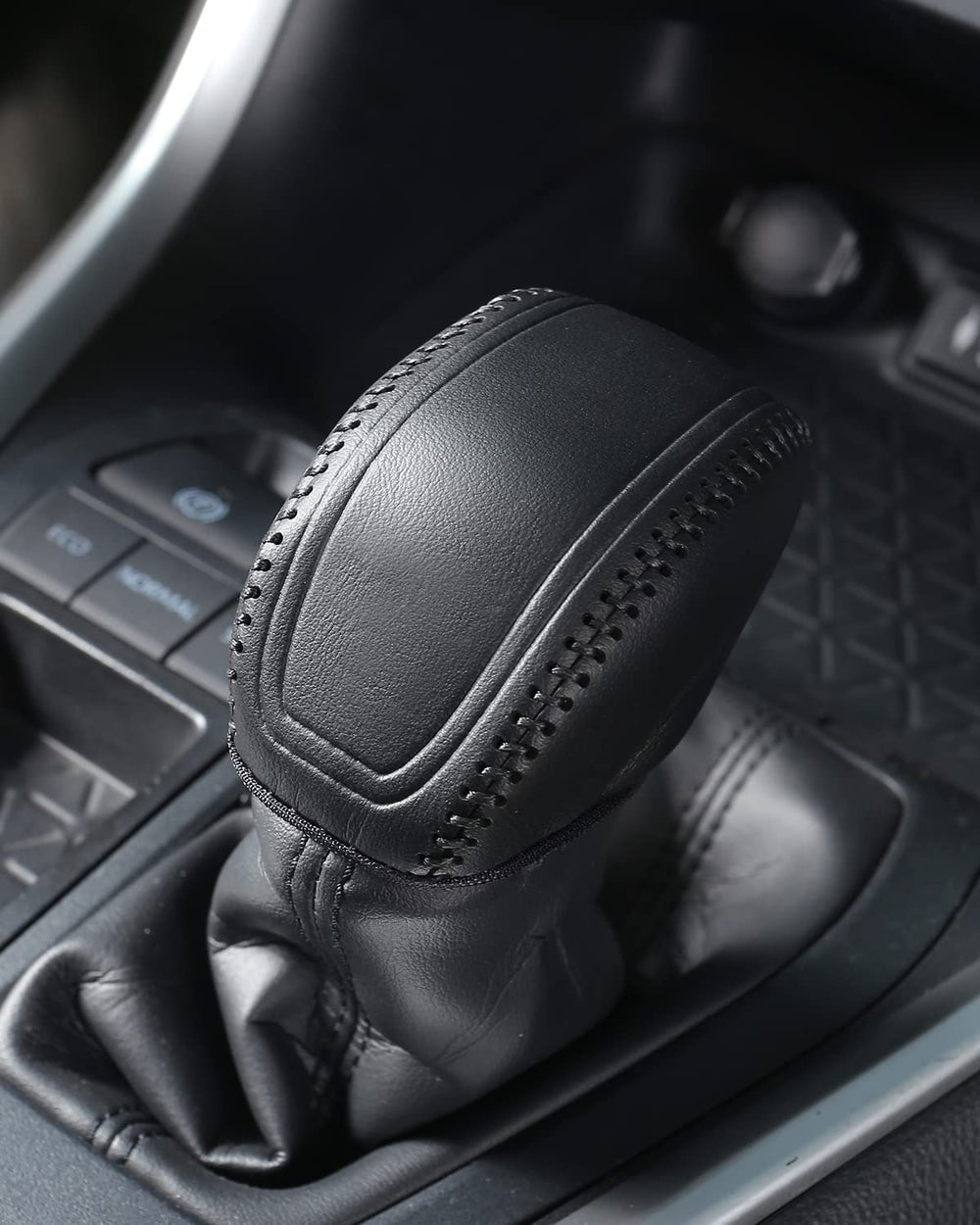 Close interior detail of YAKANEY leather gear shift cover in black
