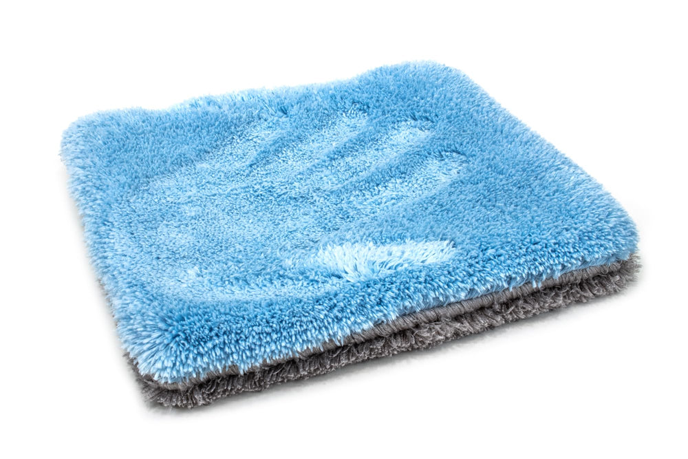 Thick microfiber pad lifting dirt and rinsing in clean water during a wash