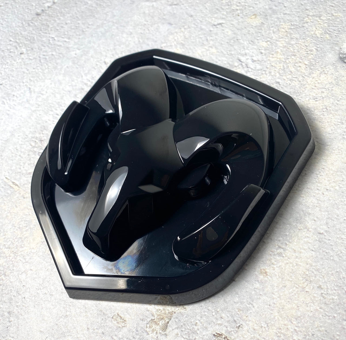Autogem grille emblem in glossy black for RAM 1500 enhances front-end style.