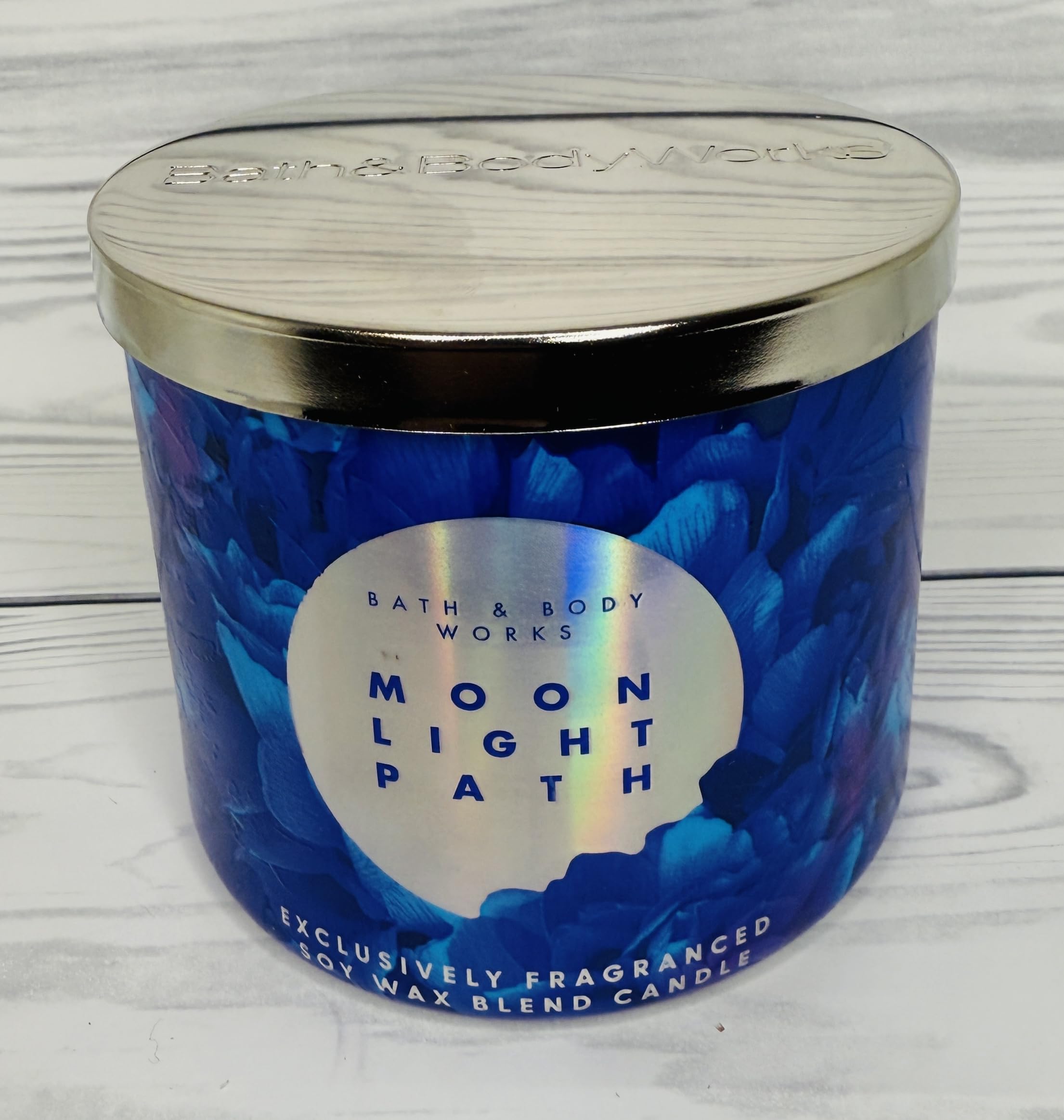 Bath and Body Works Moonlight Path candle jar on table evokes midnight garden ambiance.