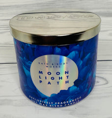 Bath and Body Works Moonlight Path candle jar on table evokes midnight garden ambiance.