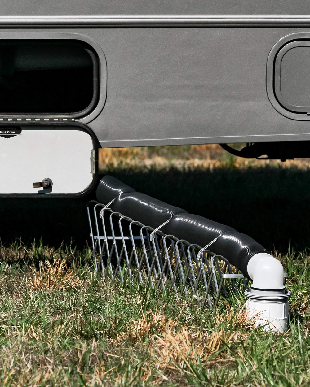 Camco translucent sewer elbow with 4-in-1 adapter for versatile drainage options.
