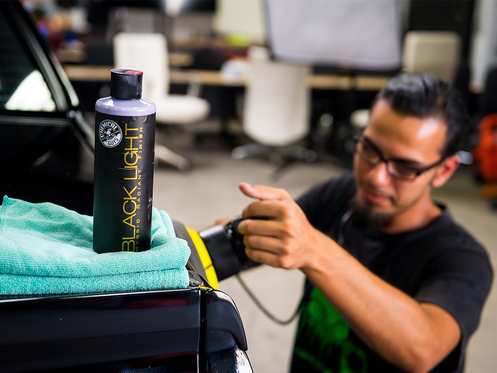 Before-and-after swirls reduced with Chemical Guys Black Light on dark finish