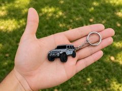 Four Wheel Beast keychain close-up highlighting raised metal enamel design and durability.