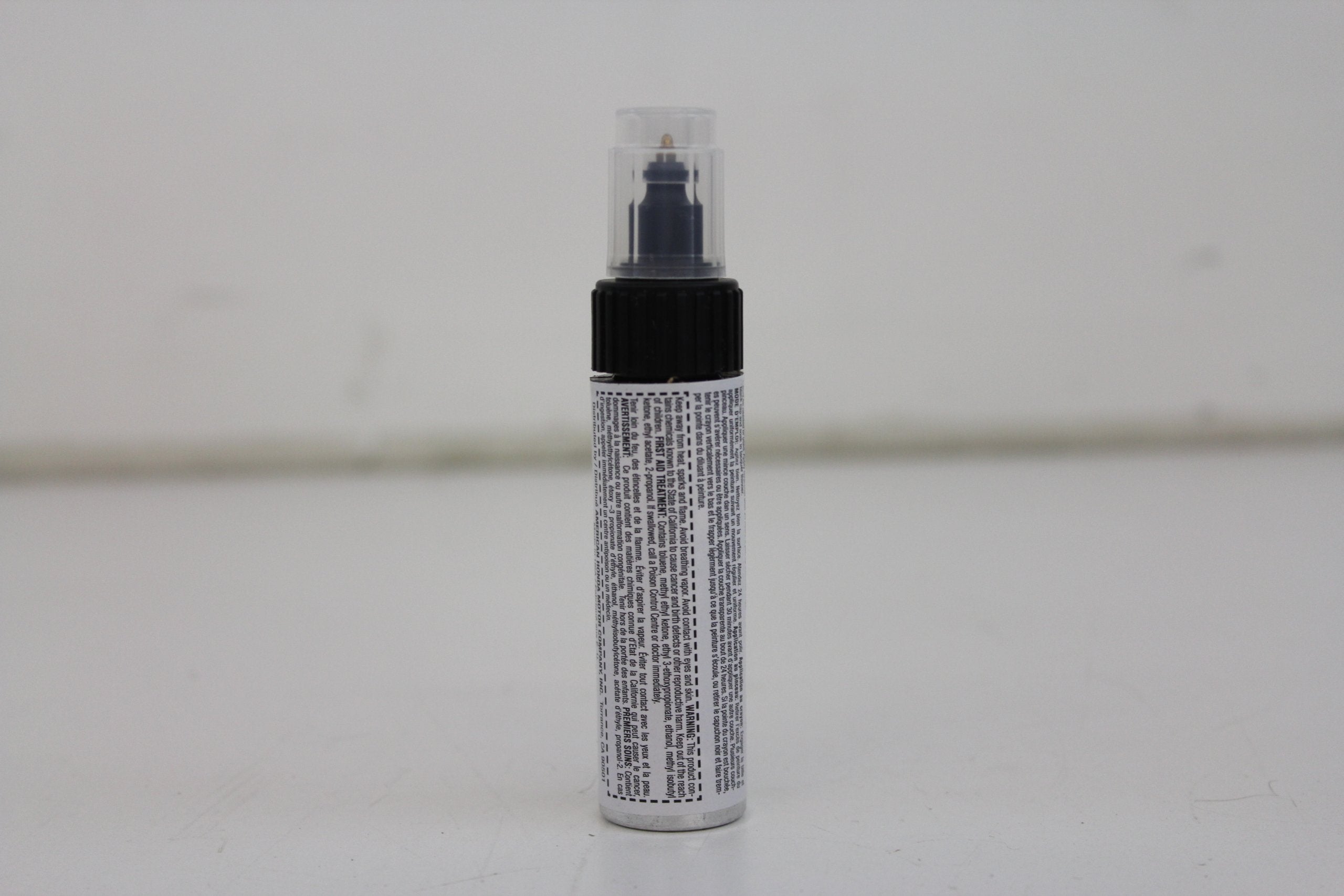 Honda Obsidian Blue Pearl touch-up paint pen cap and brush for precise scratch coverage.