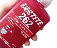 Loctite 262 red threadlocker bottle secures metal joints for reliable assembly.