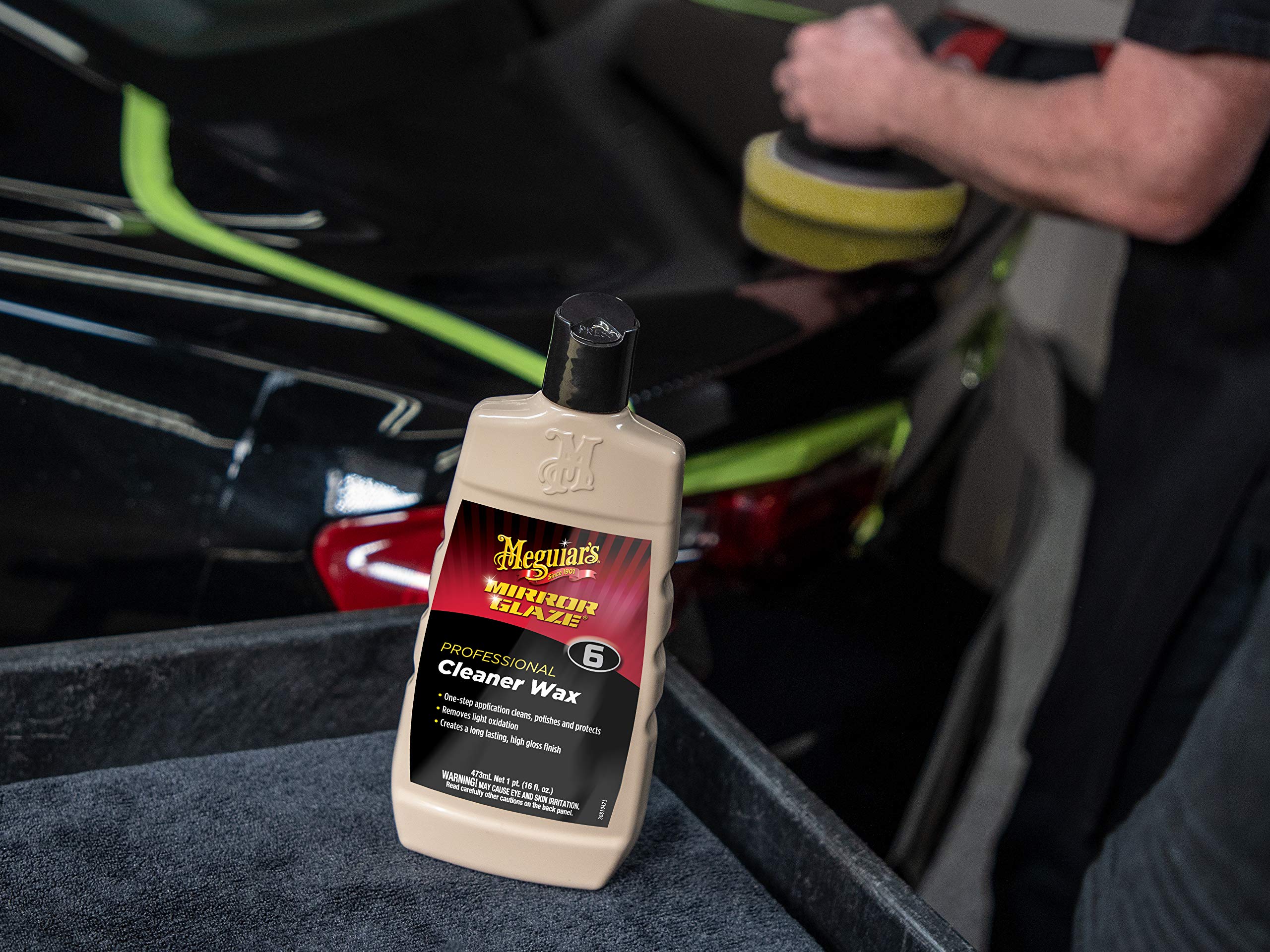 Close-up shows swirls being reduced with Meguiar's cleaner-wax for a clearer coat.