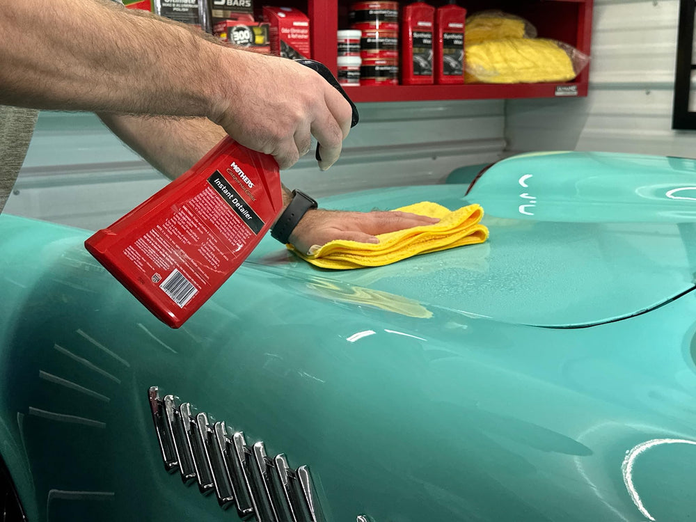 Mothers California Gold Instant Detailer near car panel removes dust for quick between-wash maintenance.