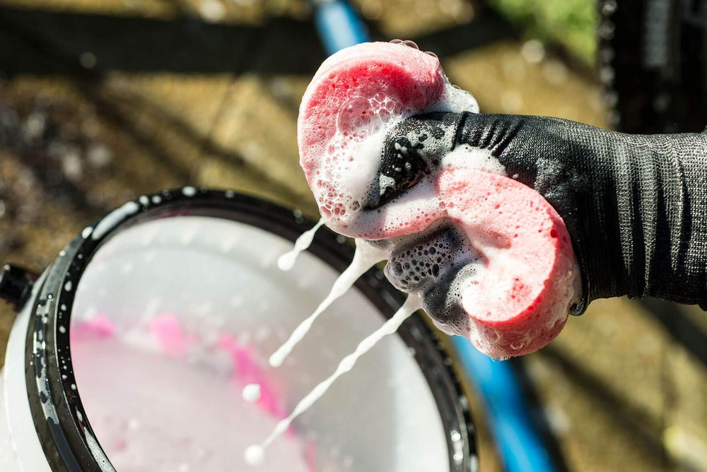 Muc-Off duo kit displayed beside a bike, suggesting an all-in-one care solution