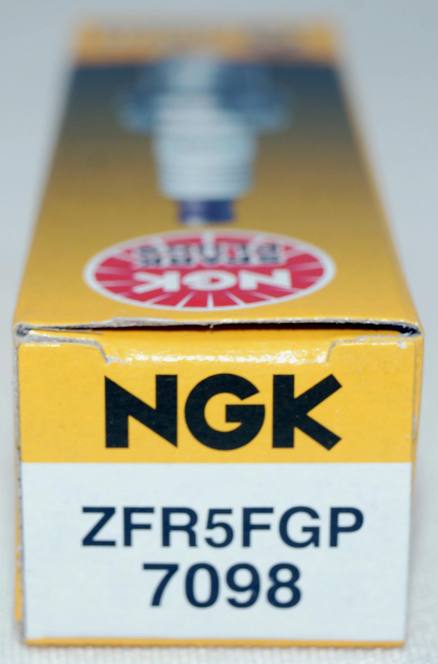 NGK 7098 G-Power spark plug installed in engine bay for reliable ignition