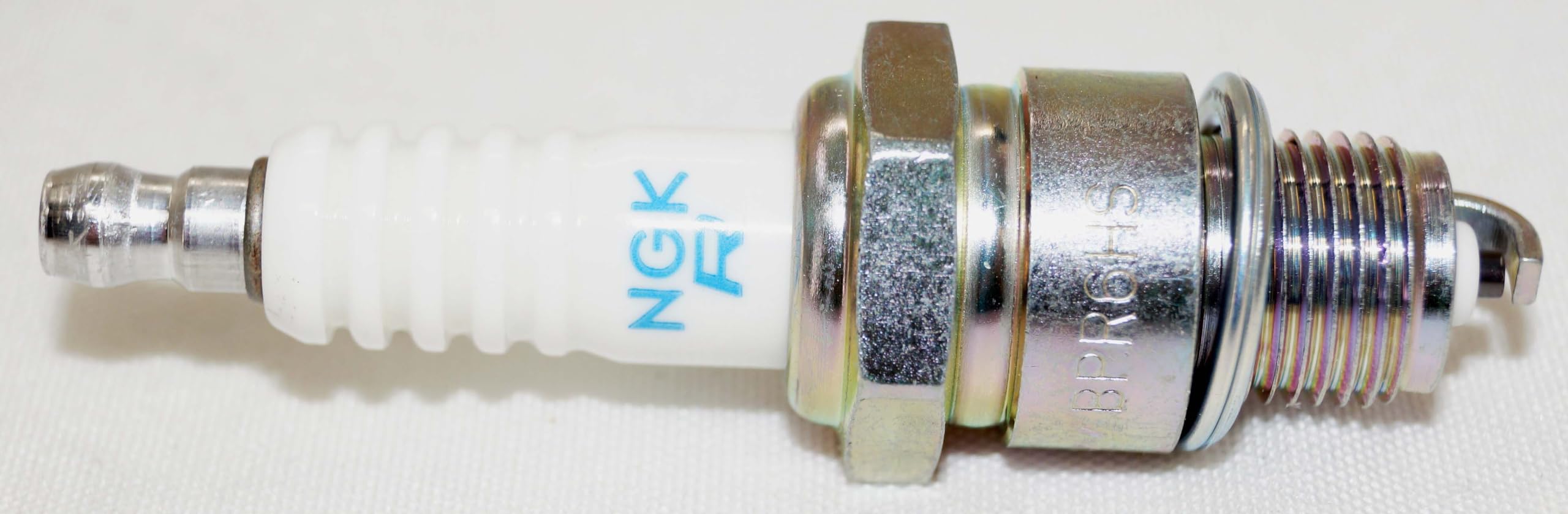 NGK BPR6HS spark plug tip and insulator close-up.