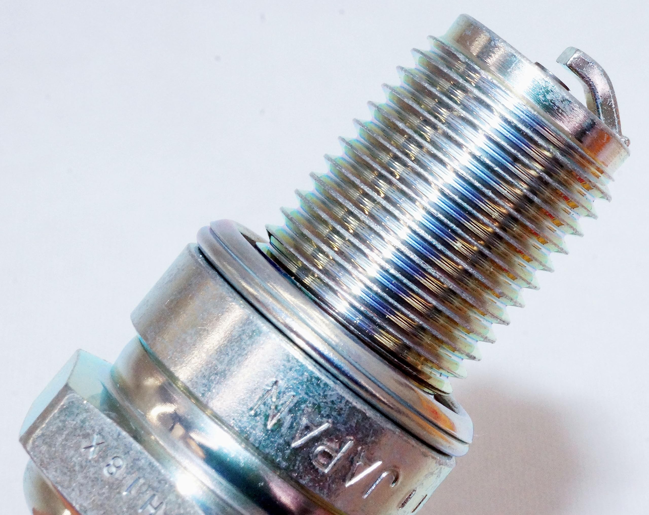In-box spark plug with hardware ready for direct replacement.