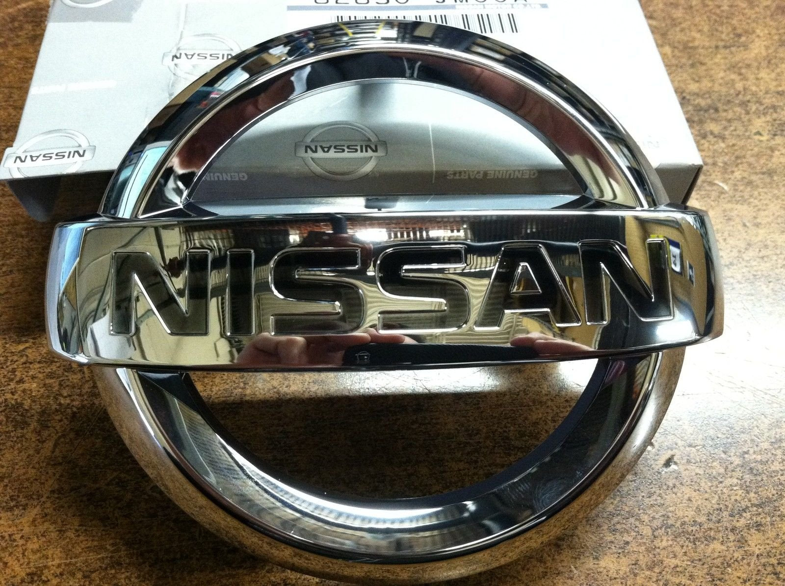 Nissan OEM front grille emblem close-up for Altima replacement