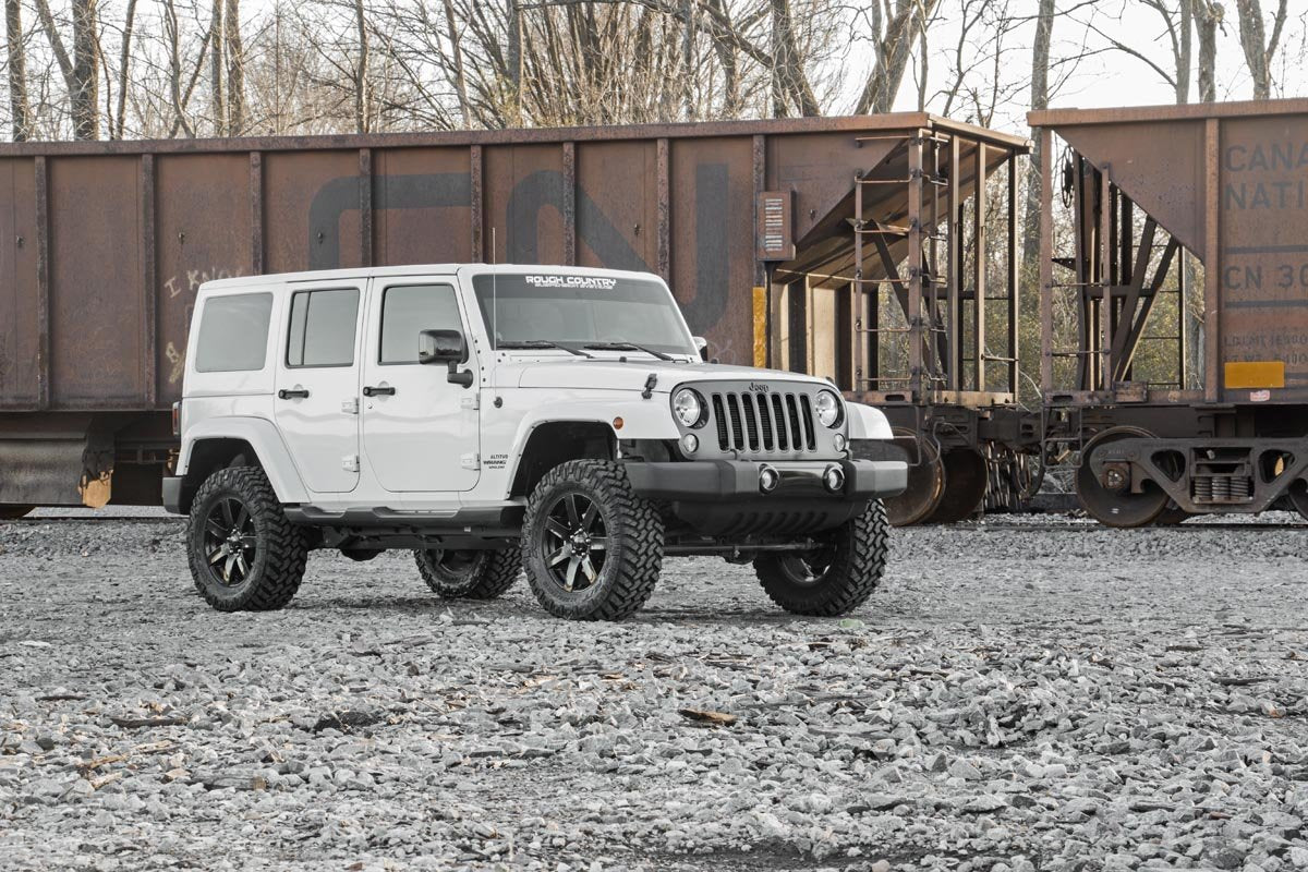 Rough Country 2.5-inch lift kit keeps Jeep JK Unlimited balanced on uneven surface.