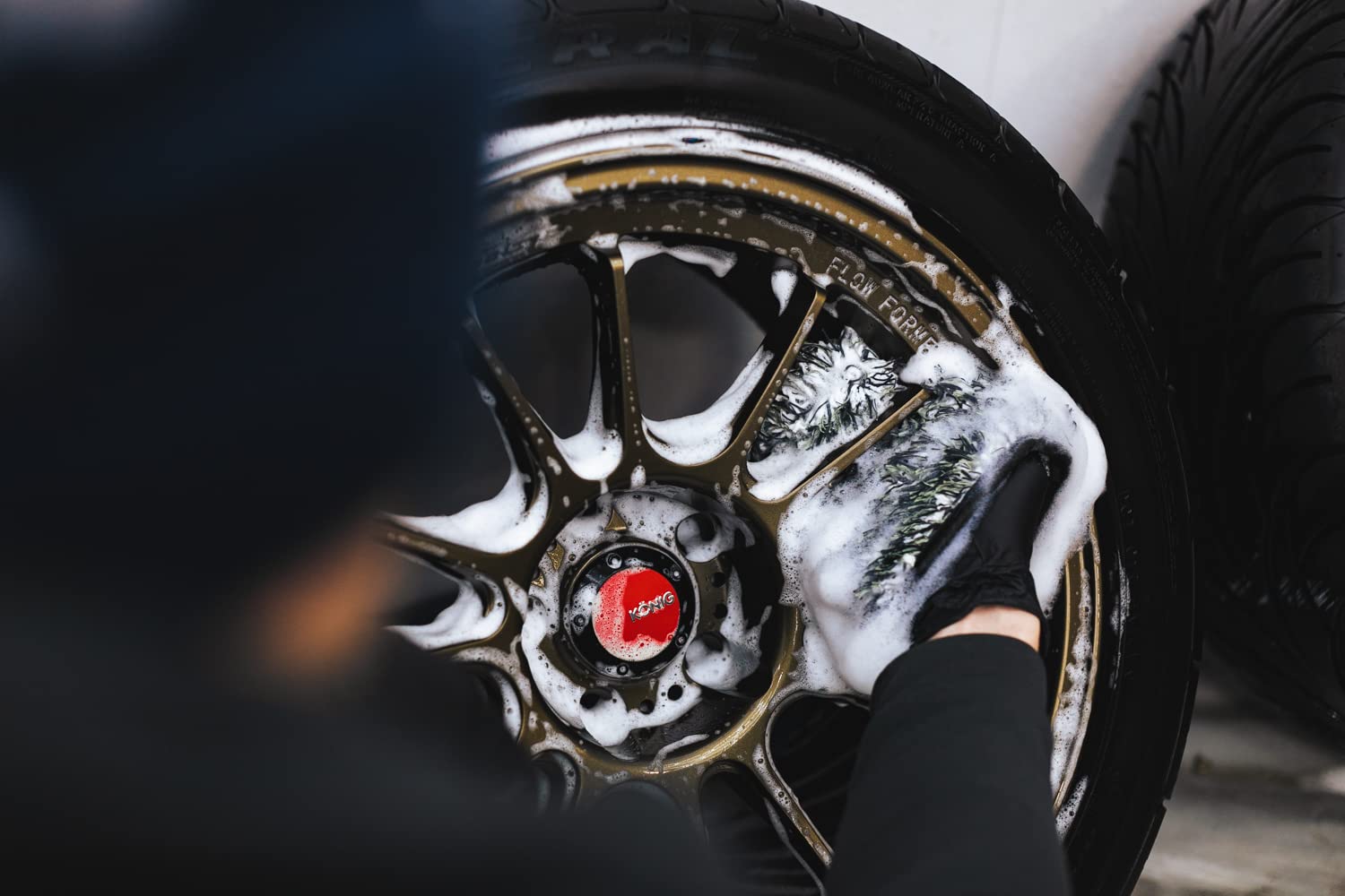 The Rag Company Cyclone Ultra Wheel Mitt reaching tight areas for detailed cleaning.