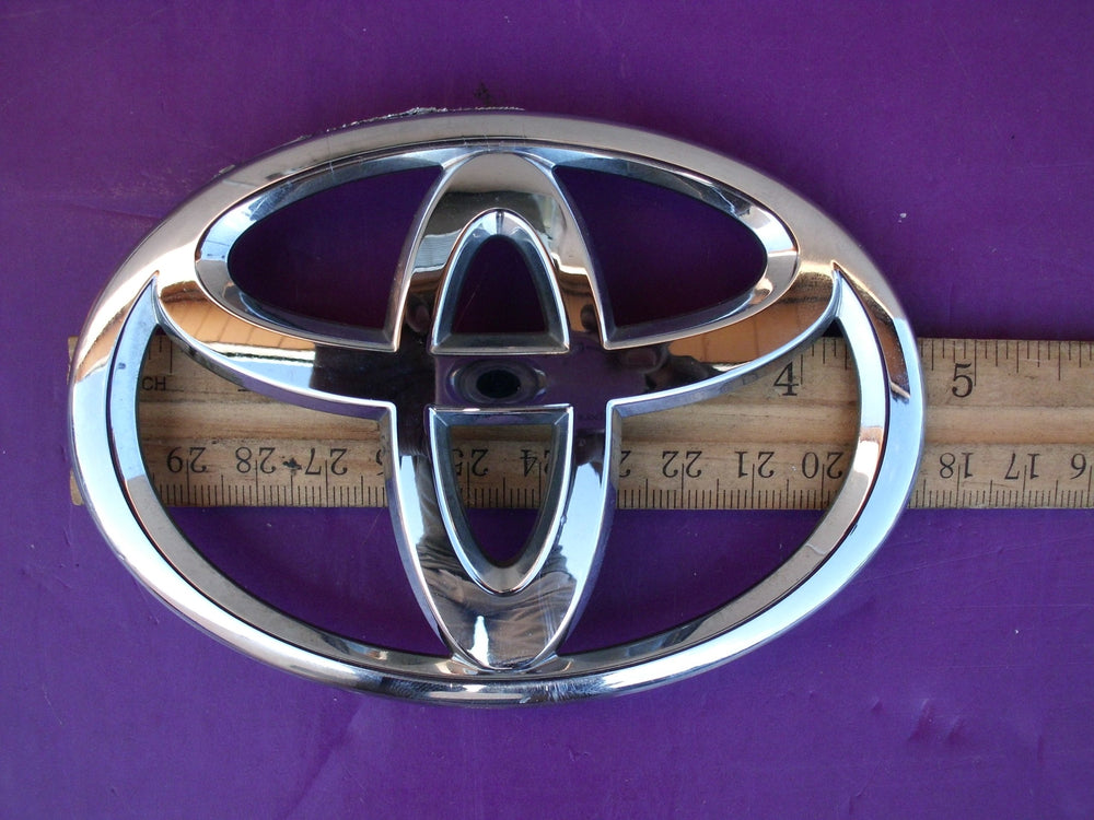 Toyota back-door emblem close-up, official OEM part with easy self-adhesive installation.