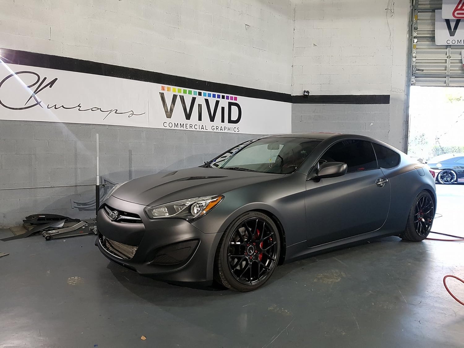 VVIVID+ matte metallic black wrap on curved panel showing seamless fit
