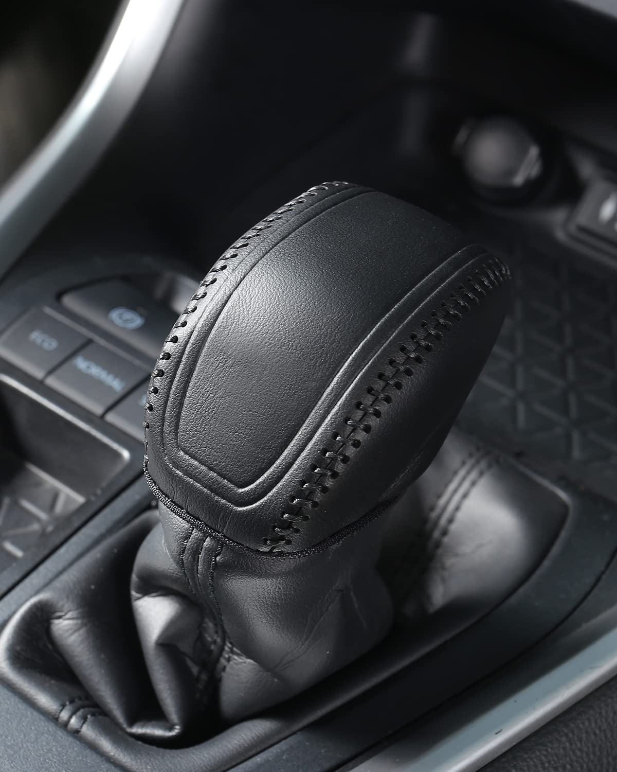 Close interior detail of YAKANEY leather gear shift cover in black