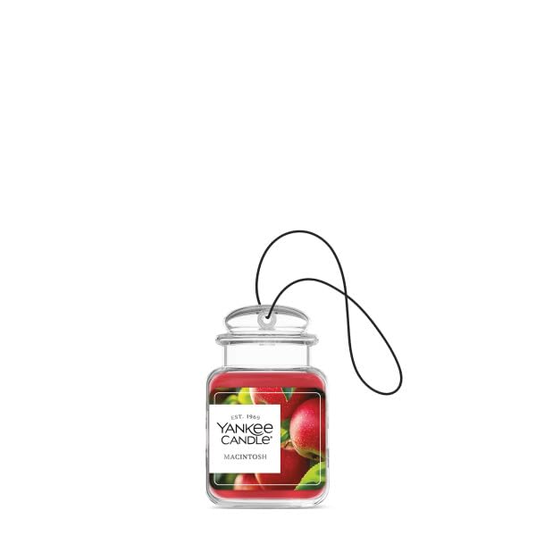 Yankee Candle Car Jar Ultimate Macintosh hanging in a car for easy attachment during drives.